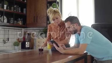 妻子正把果汁和咖啡带到厨房的桌子上，丈夫正在打字